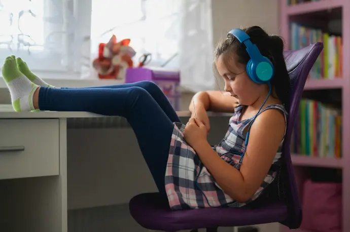 A little girl sitting in a chair with headphones on